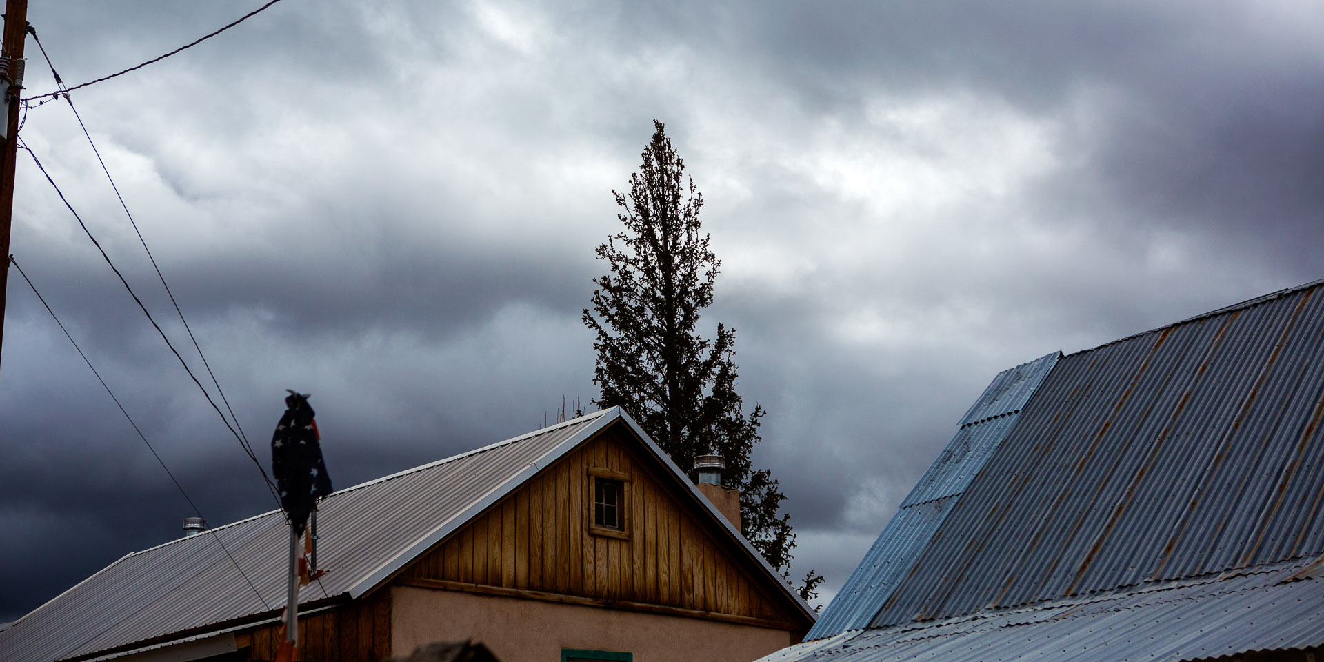 tin roofed wooden structure on cloudy day.