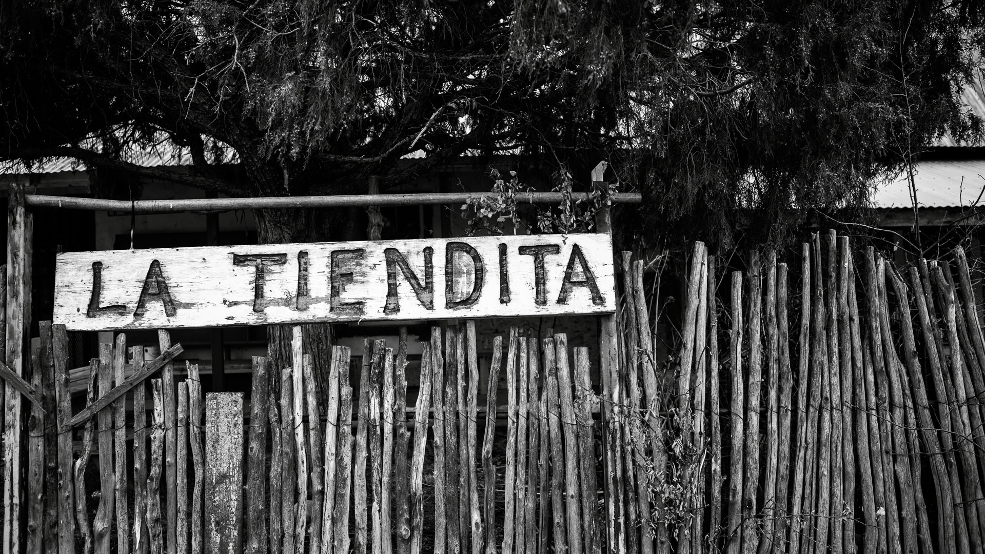 old la tiendita sign fixed to wooden fence.