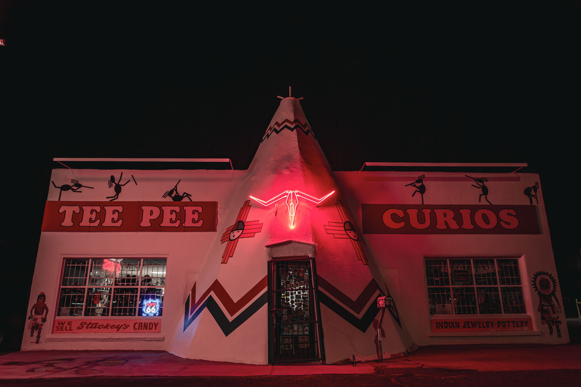 tee pee building at night with a red light.