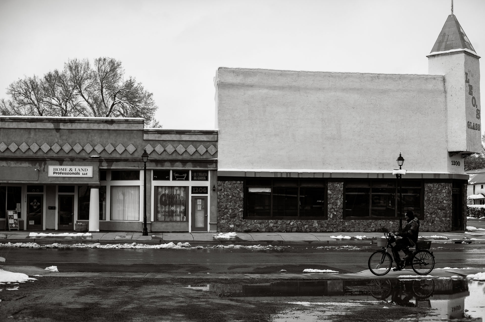 old building on main street with man riding bike.