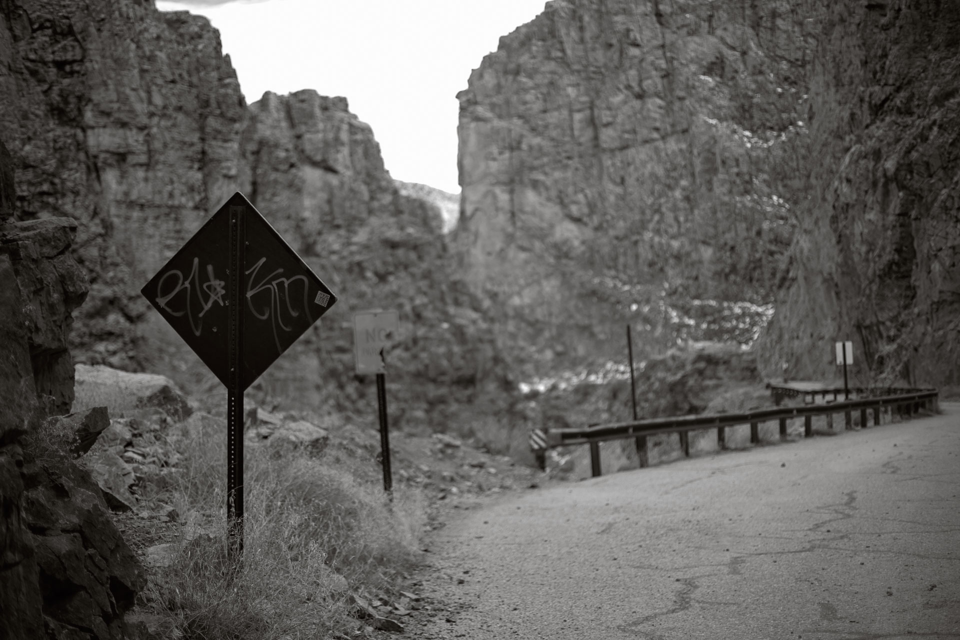 graffiti on the back of a diamond sign.