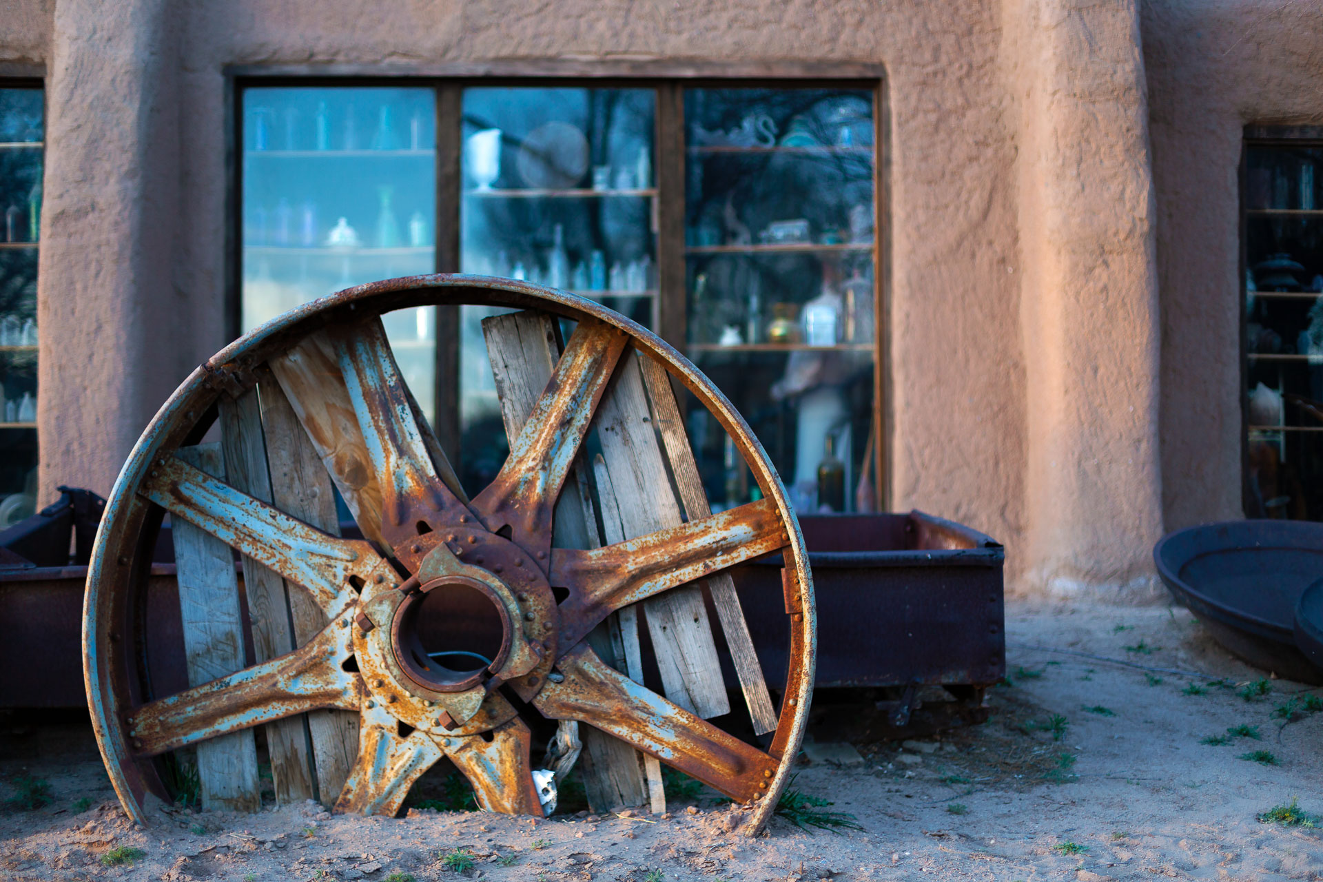 old wheel in front of windows.