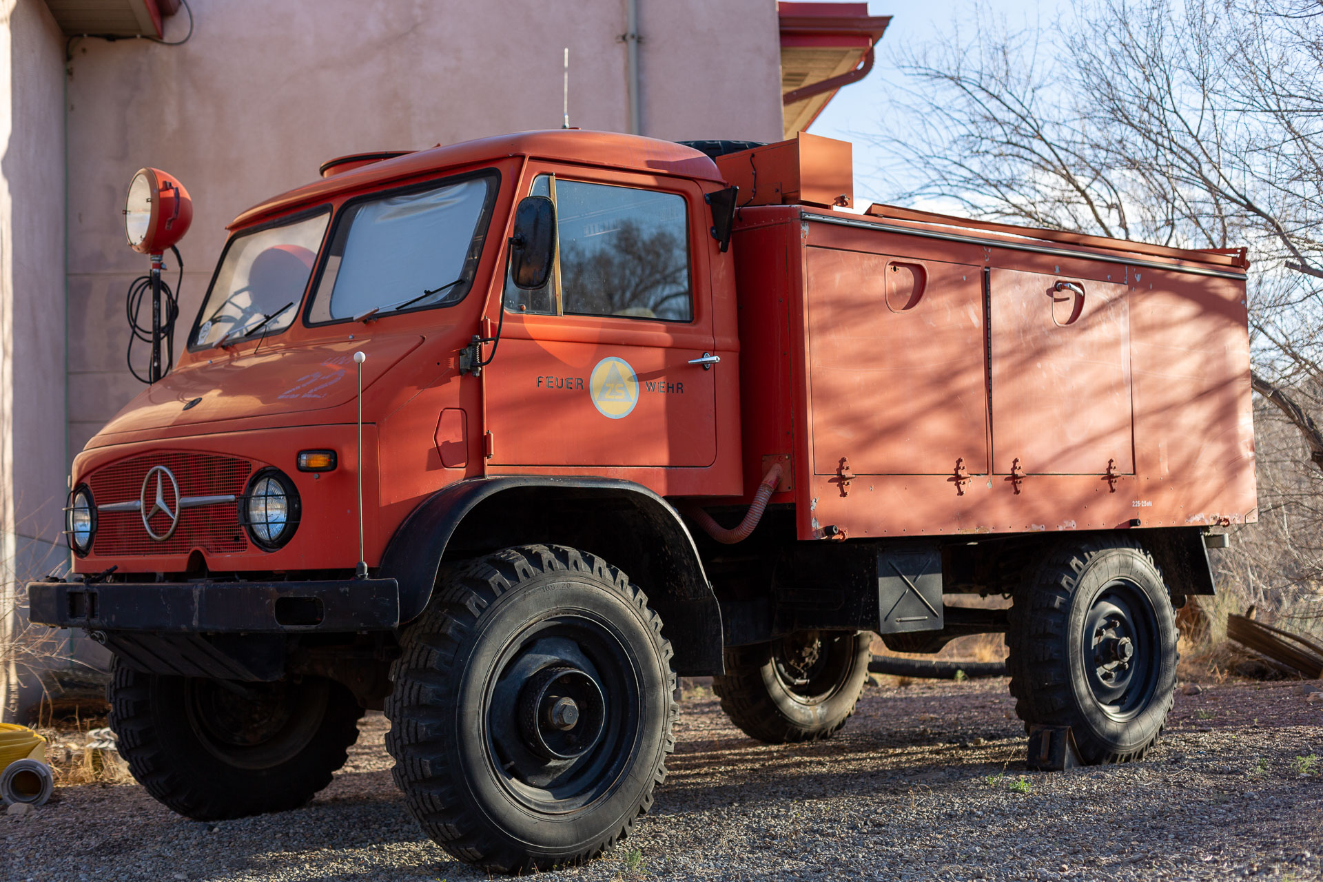 red truck in front of adobe building.