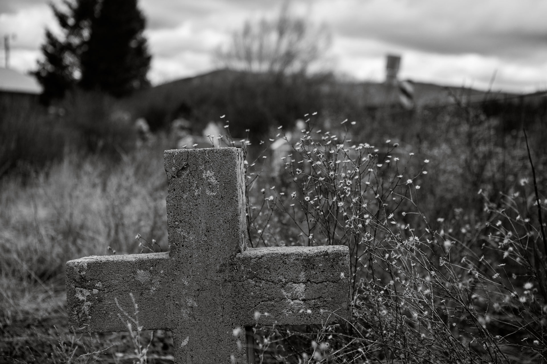 concrete cross in grass field.