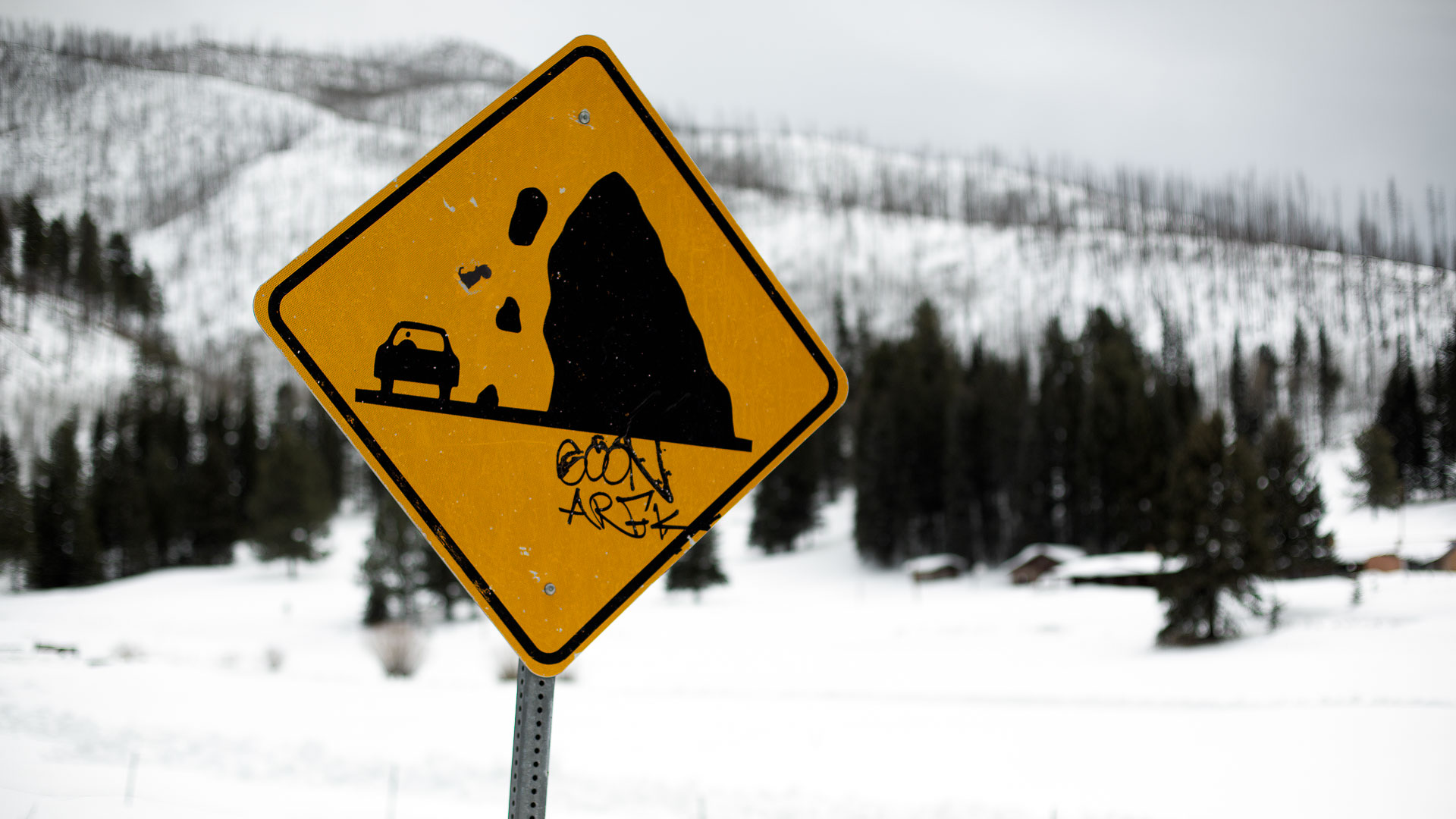 yellow sign in snowy mountain landcape.