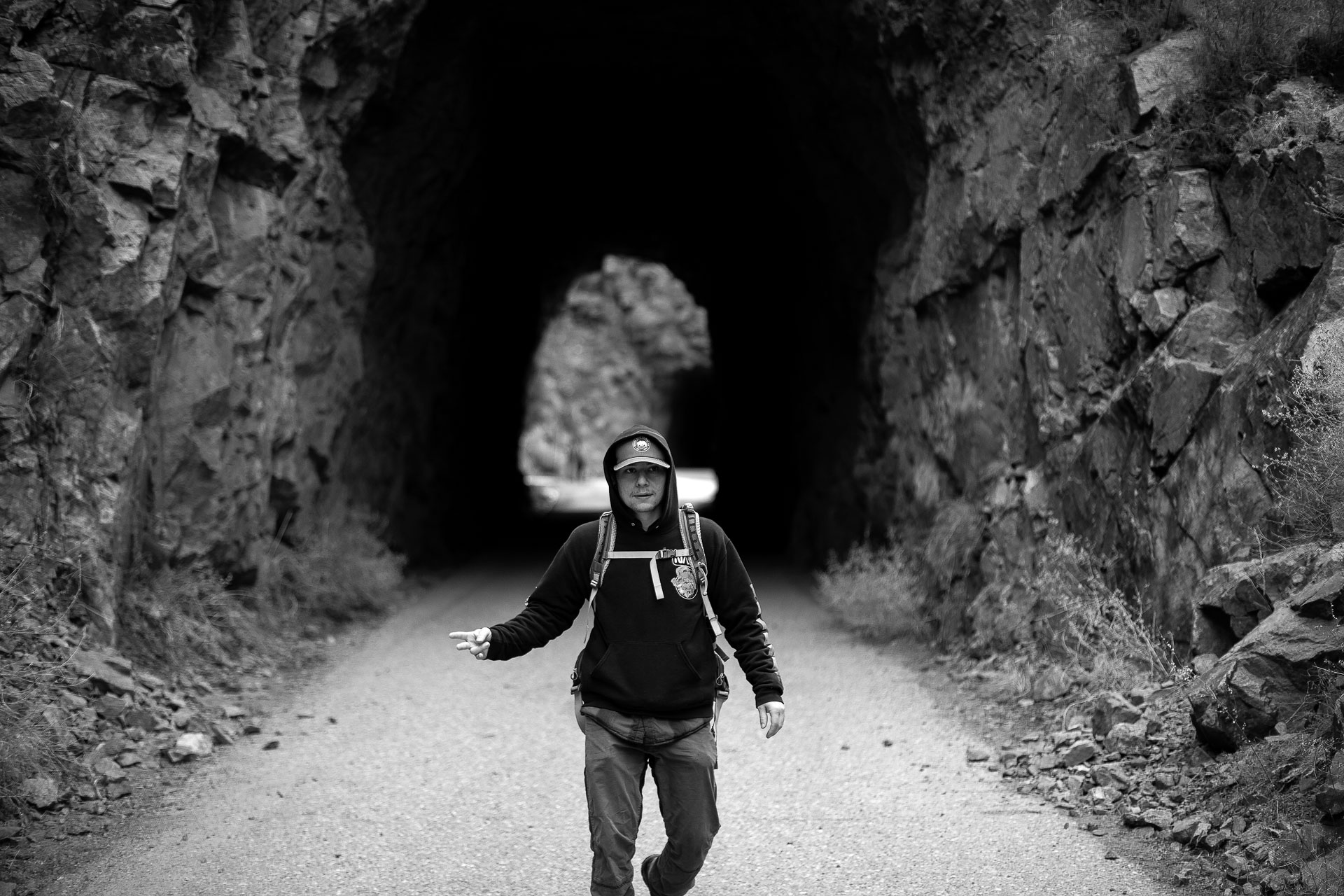 man walking through natural tunnel.