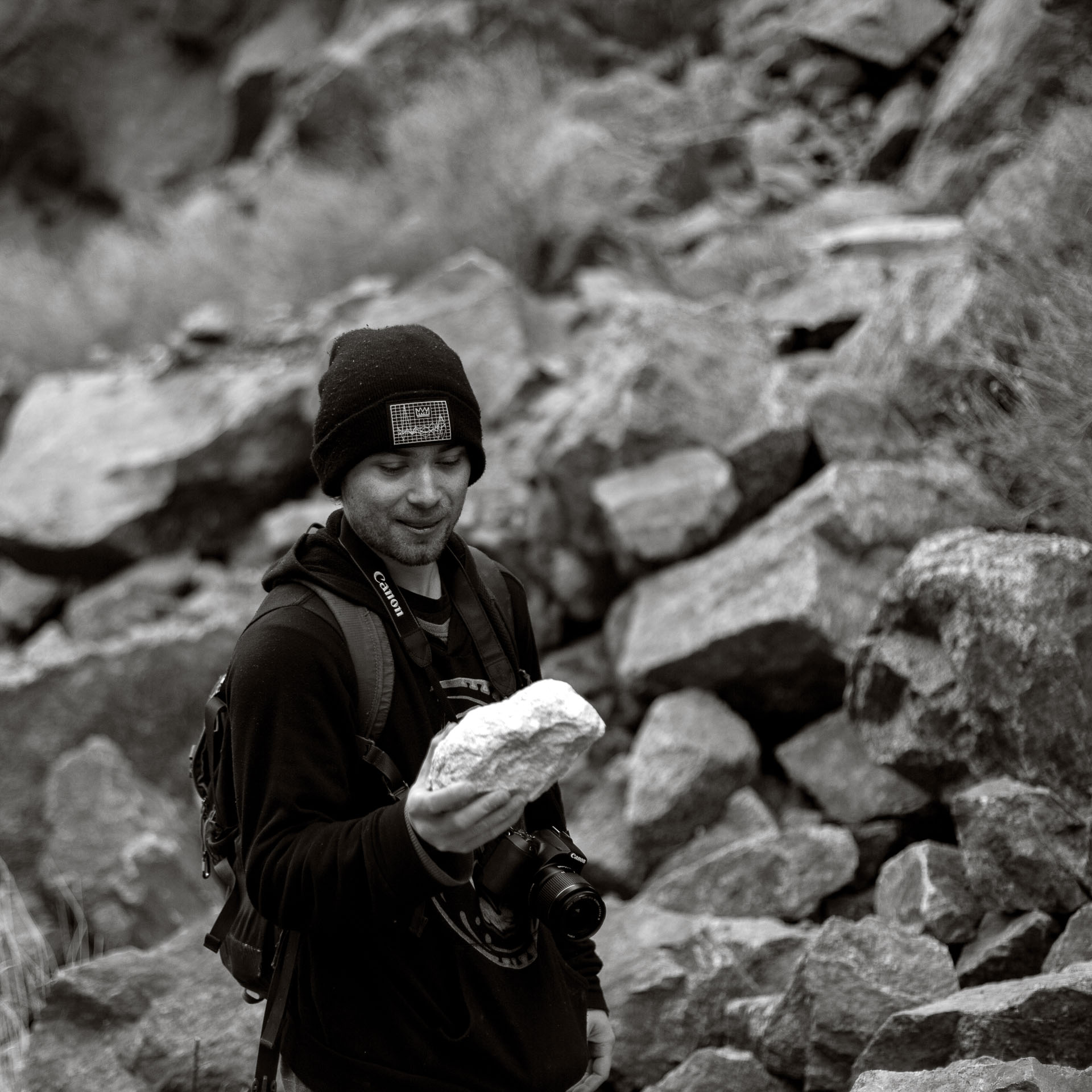 man looking at a rock.